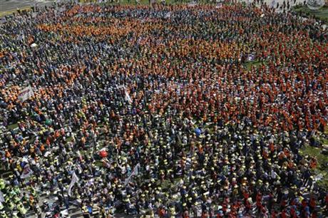 Members of Korean Confederation of Trade Unions and members of labor union of state employees shout slogans during a rally against the government labor policy in front of the Seoul City Hall in Seoul, South Korea, Saturday, April 25, 2015....