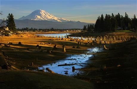 In this Feb. 17, 2015 photo, with Mount Rainier in the background, Lake Tapps near Sumner, Wash., is shown with lowered water levels due to maintenance being done by the Cascade Water Alliance, which owns the lake. With Washington state...