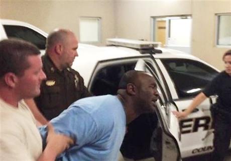 Law enforcement officers lead Curtis Banks, center, into Troop J of the Mississippi Highway Patrol in Hattiesburg, Miss., early Sunday, May 10, 2015. Banks and his brother, Marvin Banks, were arrested in connection with the fatal shootings of two...