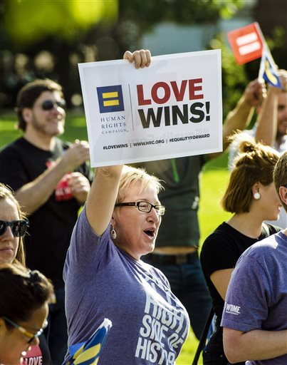 Tracy White, of Kansas City, Mo., celebrates after the Supreme Court declared that same-sex couples have a right to marry anywhere in the United States, at Ilus E. Davis Park in Kansas City, Mo., Friday, June 26, 2015(Allison Long/The Kansas City...