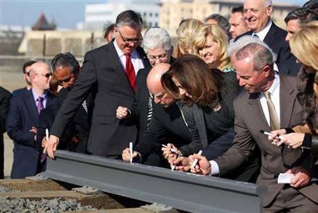 FILE - In this Jan. 6, 2015 file photo, Gov. Jerry Brown, center, and his wife, Anne Gust Brown, fourth from right, sign a portion of a rail at the California High-Speed Rail Authority groundbreaking event as Gina McCarthy, administrator of the...