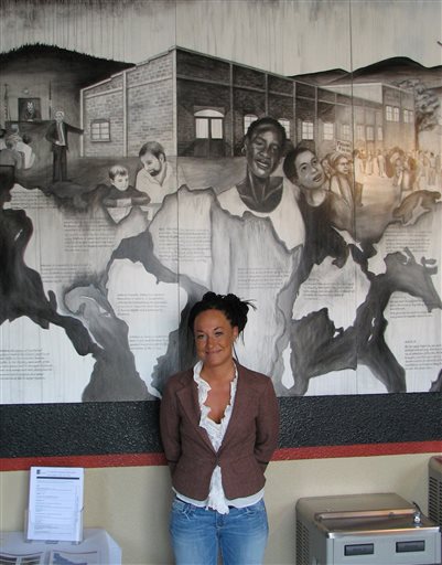 FILE - In this July 24, 2009, file photo, Rachel Dolezal, a leader of the Human Rights Education Institute, stands in front of a mural she painted at the institute's offices in Coeur d'Alene, Idaho. Dolezal, now president of the Spokane, Wash.,...