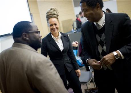 FILE - In this Friday, Jan. 16, 2015, file photo, Rachel Dolezal, center, Spokane's newly-elected NAACP president, smiles as she meets with Joseph M. King, of King's Consulting, left, and Scott Finnie, director and senior professor of Eastern...