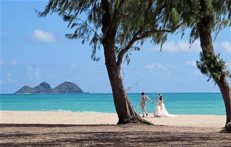 ADVANCE FOR SATURDAY, JUNE 13 - A couple from Japan takes wedding photos at Waimanalo Bay Beach Park, on Wednesday June 10, 2015 in Waimanalo, Hawaii. Residents in the small town have mixed feelings about this beach recently being declared the...