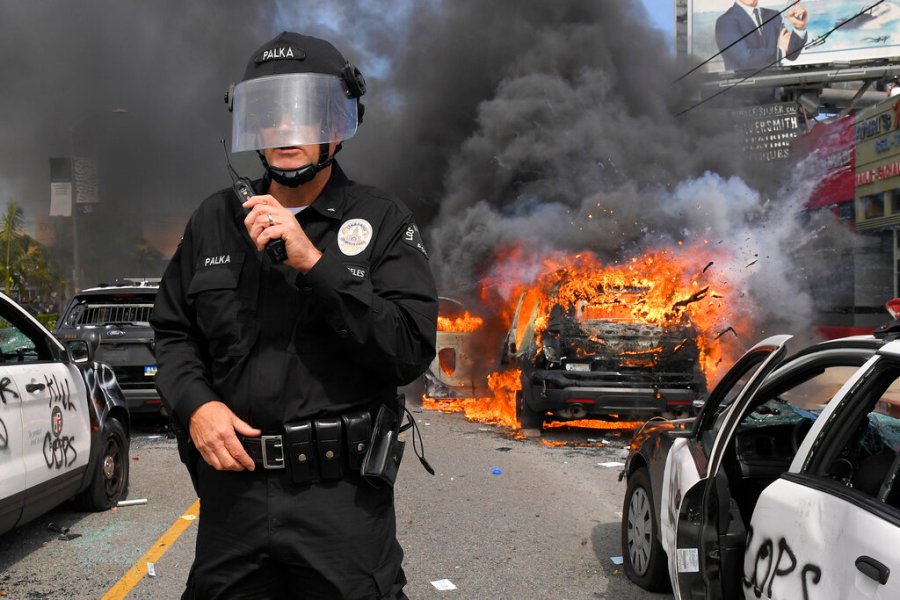 Los Angeles Police Department commander Cory Palka stands among several destroyed police cars as one burns during a protest over the death of George Floyd. (AP Photo/Mark J. Terrill)