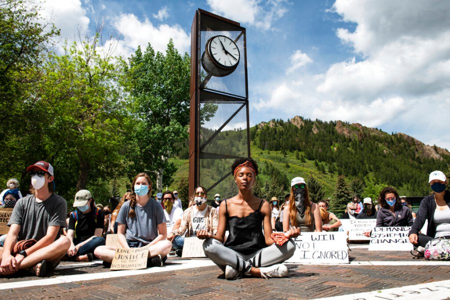 Jenelle Figgins, center, leads a moment of silent meditation before protesters march through the streets of Aspen, Colorado. (Kelsey Brunner/The Aspen Times via AP)