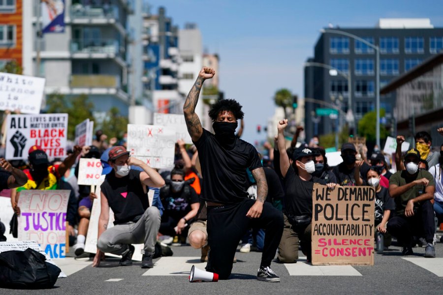 Demonstrators kneel in a moment of silence outside the Long Beach Police Department, in Long Beach, California. (AP Photo/Ashley Landis)