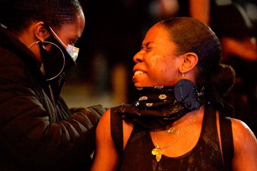 A protester squints after being sprayed with pepper spray during clashes with police in Boston. (Photo by JOSEPH PREZIOSO/AFP via Getty Images)