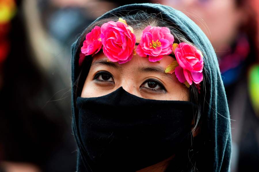 A demonstrator wears a ring of roses along with a face mask during a protest in Denver. (Photo by JASON CONNOLLY/AFP via Getty Images)