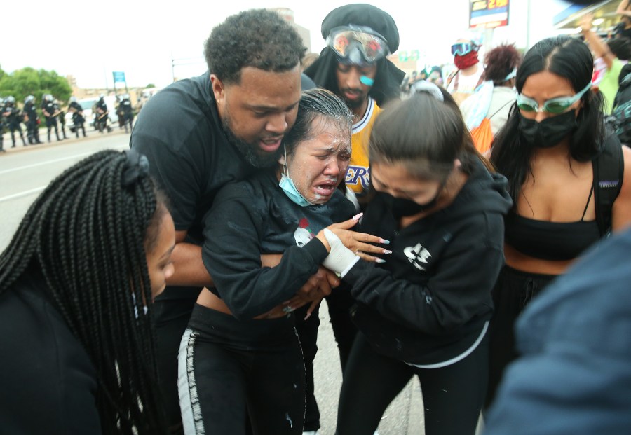 A women is helped after being pepper sprayed during a protest against police brutality and the death of George Floyd, on May 31, 2020 in Minneapolis, Minnesota. (Photo by Scott Olson/Getty Images)