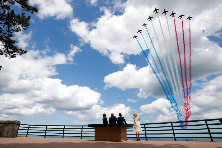 In this June 6, 2019 file photo, President Donald Trump, first lady Melania Trump, French President Emmanuel Macron and Brigitte Macron, watch a flyover during a ceremony to commemorate the 75th anniversary of D-Day at the American Normandy cemetery, in Colleville-sur-Mer, Normandy, France. In sharp contrast to the 75th anniversary of D-Day, this year's 76th will be one of the loneliest remembrances ever, as the coronavirus pandemic is keeping nearly everyone from traveling. (AP Photo/Alex Brandon, File)