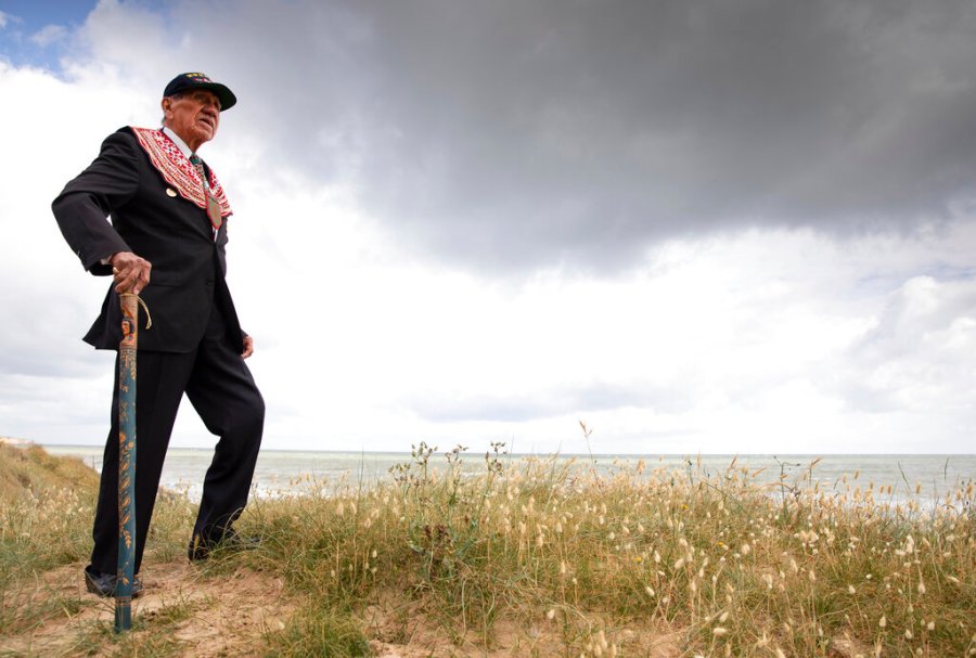 World War II D-Day veteran and Penobscot Elder from Maine, Charles Norman Shay, poses on the dune overlooking Omaha Beach prior to a ceremony in Saint-Laurent-sur-Mer, Normandy, France. Saturday's anniversary of D-Day will be one of the loneliest remembrances ever, as the coronavirus pandemic is keeping almost everyone away, from government leaders to frail veterans who might not get another chance for a final farewell to their unlucky comrades. (AP Photo/Virginia Mayo)